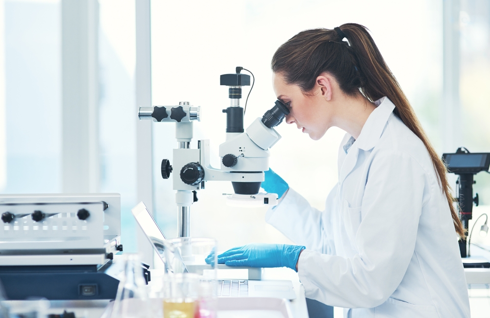 Scientist and microscope at laboratory with ergonomic lab seating