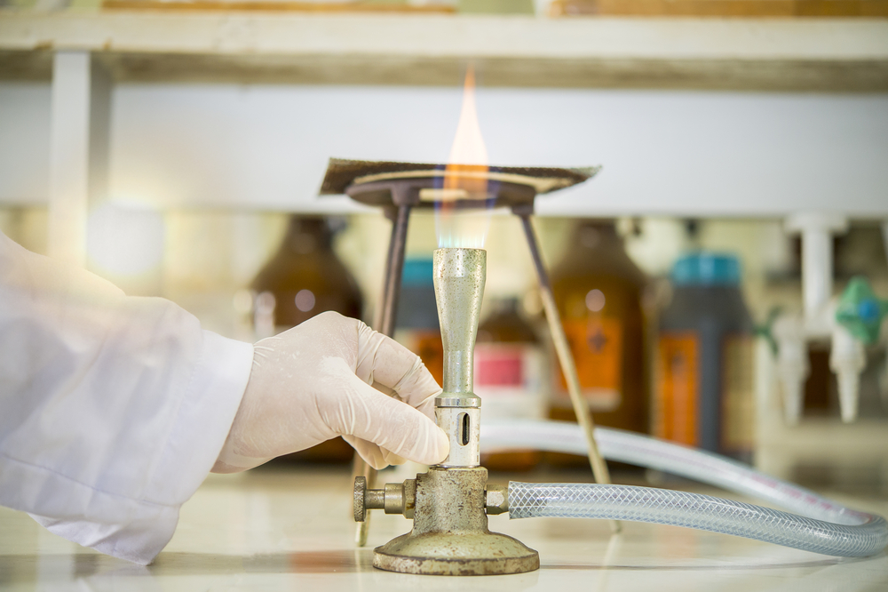 Scientist working with flame on fire-resistant materials
