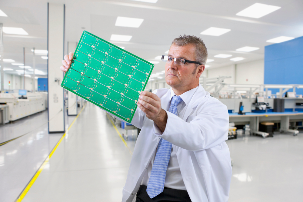 Technician Examining Printed Circuit Board In Electronics Lab with anti-static lab flooring