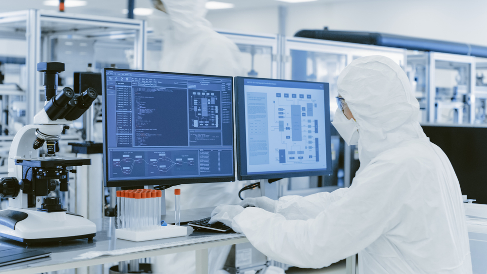 Food Scientist in Protective Clothes Doing Research on a Compute